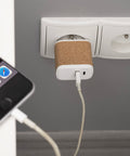 BLOSETO USB-C elektrotīkla lādētājs ar korķa apdari un logo, fonā telefons
