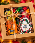 Ziemassvētku dāvanu komplekts KRĀSAINAIS brūnā kastē ar logu, džutas auklu, Rudy’s Kombucha, Pūres konfektēm un personalizētu piparkūku cimda formā