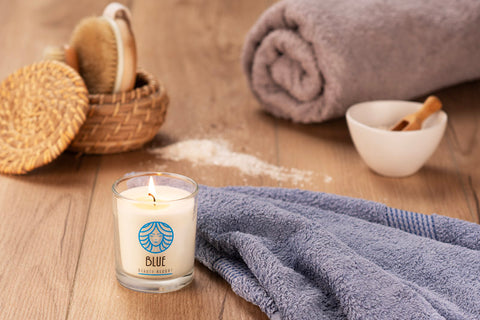 VERA YOUNG Lemongrass & Ginger sojas svece ar logo druku, fonā dvieļi