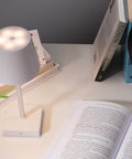 VIDIA LED galda lampa birojam ar logo, fonā galds un lampas