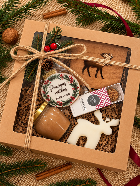 Korporatīvā Ziemassvētku dāvana Ziemas miers brūnā kastē ar džutas auklu, koka paliktni ar aļņa motīvu un personalizētu piparkūku